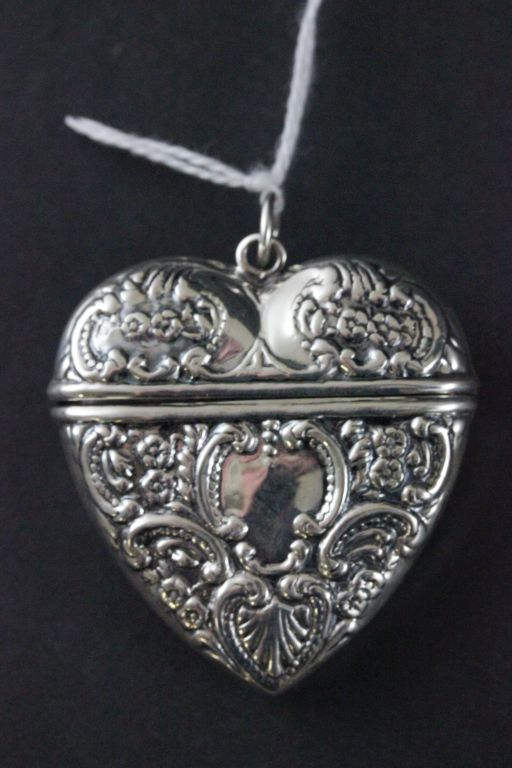 A silver heart shaped vesta case