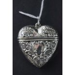 A silver heart shaped vesta case