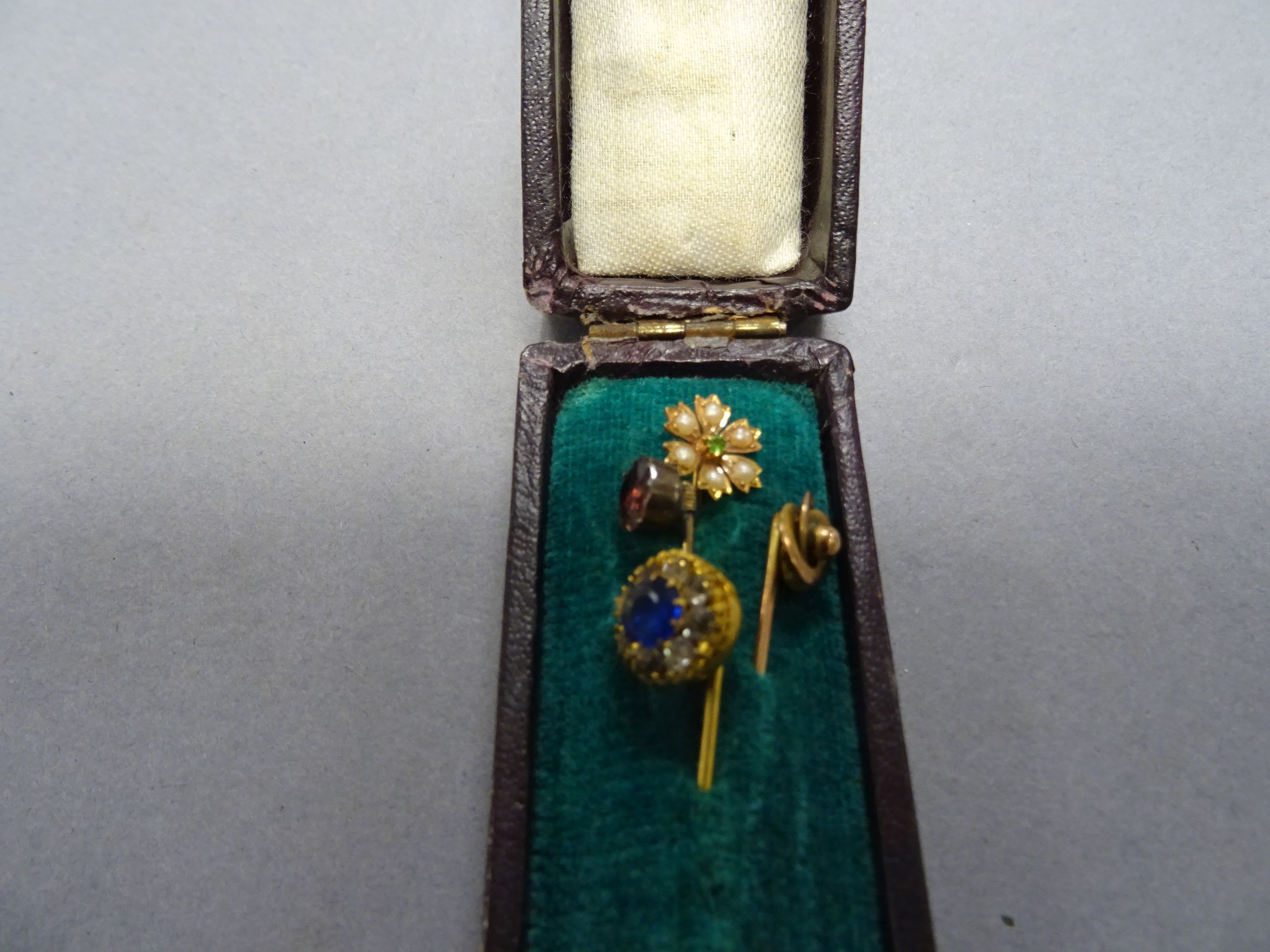 Four 19th / Early 20th century Yellow Metal Stick Pins, one marked 9ct with seed pearls and peridot