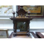 An oak cased antique mantle clock of classical form with two train movement and brass face raised on