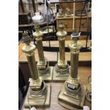 Four Corinthian style brass table lamps with square bases