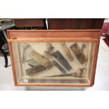 Glass display case with various vintage tools, planes, saws, levels etc