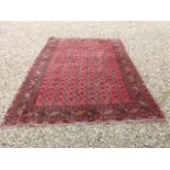 A red Afghan rug with elephant's feet design, approx 6ft 6in x 8ft 6in