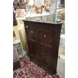 A 19th century mahogany corner cupboard with paneled door opening to reveal shelved interior.