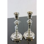 A pair of silver candlesticks, with mahogany weighted bases, London 1913, 23cm high