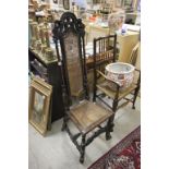 An antique Jacobean oak hall chair of narrow form with rattan seat and back rest .