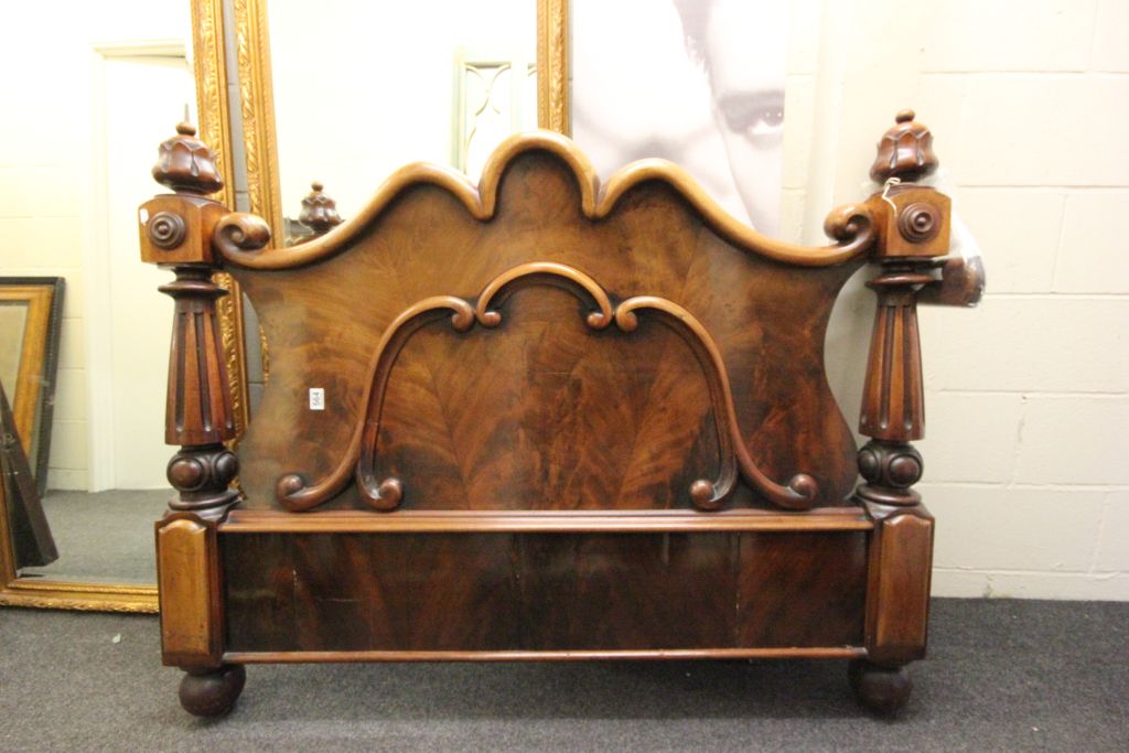 An antique continental flamed mahogany foot board of classical design.