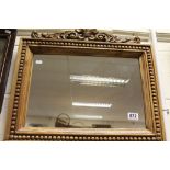 Wooden framed wall mirror with fleur-de-lys motif to the top edge