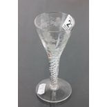 A wine glass with air twist stem and grape vine decoration to bowl