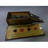 A good quality brass and oak cribbage board, plus a boxed set of dominoes