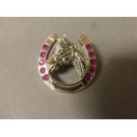 A silver and ruby lucky horse shoe brooch/pendant