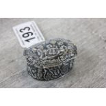 A silver ring box with embossed decoration