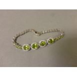 A silver bracelet set with peridots and cz's