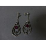 A pair of silver earrings inset with marcasites and ruby drops