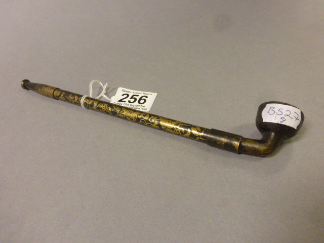 A telescopic antique bronze opium pipe with gilt floral decoration to stem