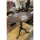 A late Victorian mahogany tilt top table with shaped top and hairy paw feet