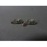 A pair of silver Cartier style earrings set with emeralds and ruby drops