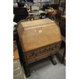 A mid 20th Century oak geometric topped bureau raised on trestle support