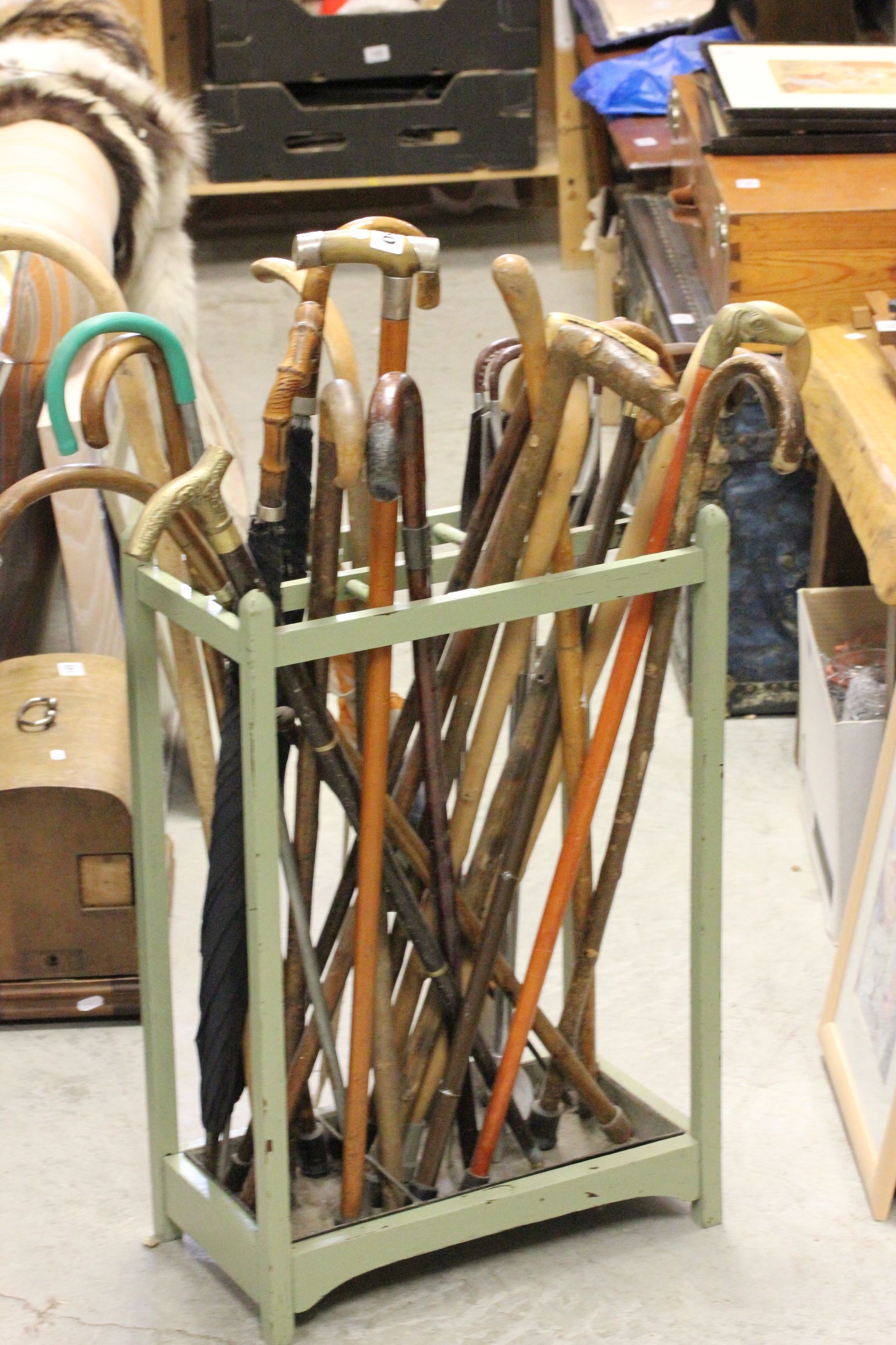 A painted oak stick stand with original metal drip tray and an assortment of 19 vintage walking