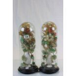 Two 19th Century tall vases of floral displays on ebonised circular plinths, 41cm in height