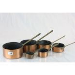 Set of Six Graduating Copper Saucepans with Brass Handles