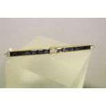 Impressive Art Deco Gold Bar Brooch set with Central Diamond, Twelve Channel Set Sapphires and Two