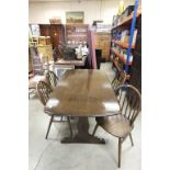 Ercol Dark Elm Refectory Style Dining Table together with Four Ercol Hoop Back Dining Chairs