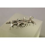 Silver brooch in the form of three horses galloping