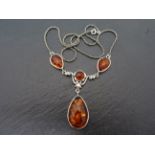 A silver and amber style three section necklace