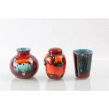 Three pieces of Poole pottery to include a small lidded jar, all in vibrant colour