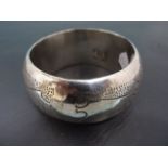 Heavy bangle with hand punched decoration and hallmarked "Silver"