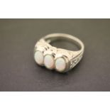 A silver ring with three oval shaped opal panels