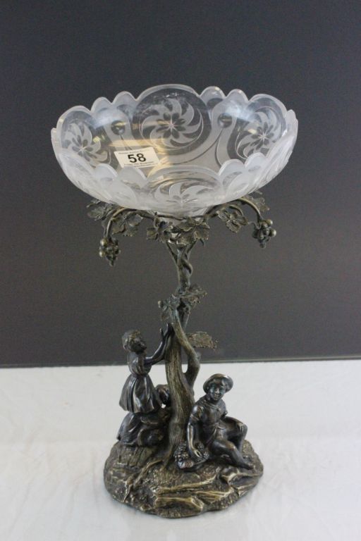 A cut glass bowl on a cast metal stand depicting two figures grape picking