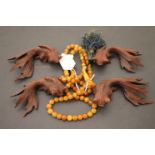 Chinese amber bead necklace, plus four hardwood goldfish sculptures