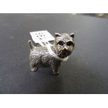 A heavy cast silver figure of a dog with garnet eyes