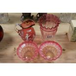 A Mary Gregory style cranberry jug a pair of crimp edged cranberry bowls and similar shade.