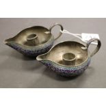 SA pair of of pewter and enamel chamber sticks.