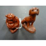 Two wooden netsukes of a monkey eating and a dog