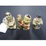 group of three netsuke style resin carvings of baby with cat, basket maker and a fisherman
