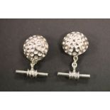 A pair of silver golf ball style cufflinks