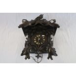 A vintage Black forest cuckoo clock with bird and leaf decoration.