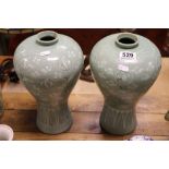 A pair of oriental celadon style vases with stork decoration signed to base.