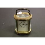 French Brass Carriage clock with an oval form and enamel dial