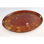 Large Red Toleware Oval Serving Tray with Gilt decoration of leaves and vines