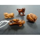 Four miniature netsukes to include frog on fish, owl, dog of foe and Chinese dragon