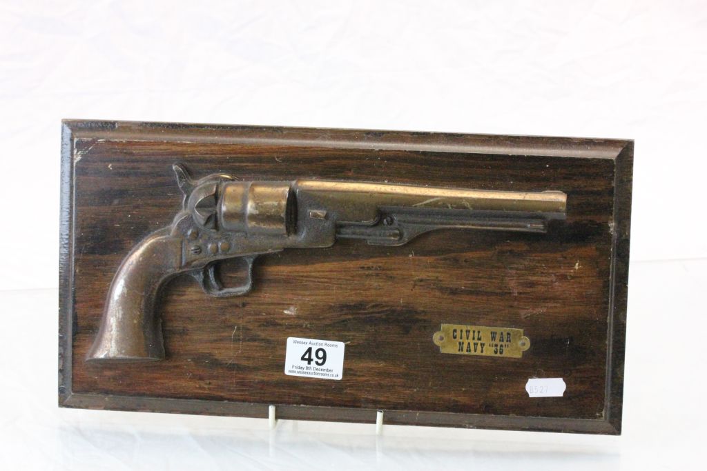 A replica half model of a Colt 45 on wooden plaque.