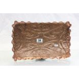 A copper arts and crafts embossed tray with crimped edge.