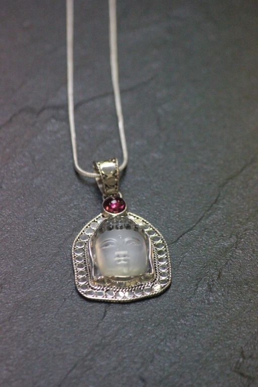 A silver rock crystal buddha pendant necklace with pink sapphire mount - Image 2 of 2