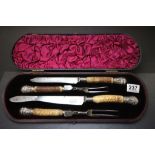 Cased set of four meat carving items with horn handles and hallmarked Silver ends