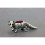 A silver fox pincushion with ruby eyes